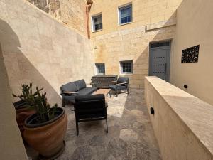 a patio with a couch and chairs in a building at 3 Doni in Rabat