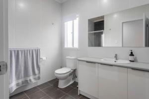 a white bathroom with a toilet and a sink at Allawah in Encounter Bay +26 photos