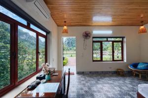 a room with a table and some windows at Chinh Thu Garden Retreat in Ninh Binh