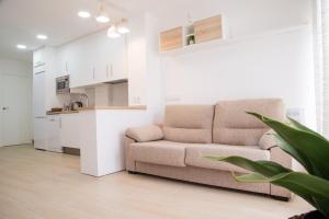 a living room with a couch and a kitchen at Hospedium GL Andújar Boutique in Andújar