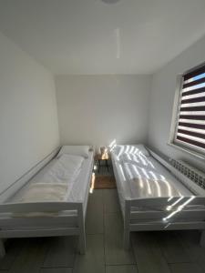 a bedroom with two beds and a window at Apartman Ćorić in Kiseljak