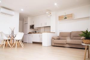 a kitchen and a living room with a couch and a table at Hospedium GL Andújar Boutique in Andújar +8 photos
