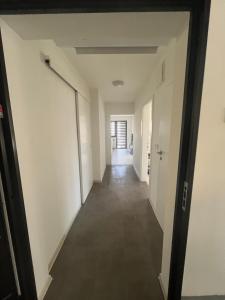 a hallway of an office building with white walls and a long corridor at Apartman Ćorić in Kiseljak
