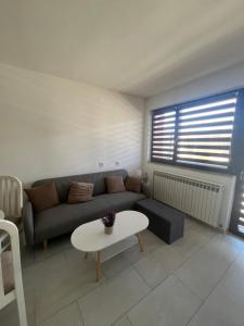 a living room with a couch and a table at Apartman Ćorić in Kiseljak