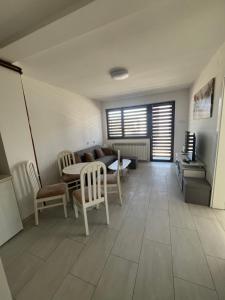 a living room with a couch and a table and chairs at Apartman Ćorić in Kiseljak