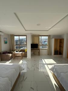 a large white room with a bed and a living room at Golden Bay Hotel in Al Hoceïma