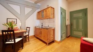 eine Küche mit einem Tisch und eine Küche mit einer grünen Tür in der Unterkunft Altstadt Gästehaus Drewes Wale in Lüneburg
