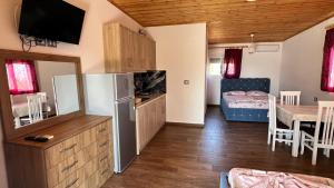 a kitchen and living room with a refrigerator and a table at Seaside Ksamil in Ksamil