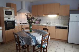 a kitchen with a table with a vase of flowers on it at La bellevue in Lapeyrugue