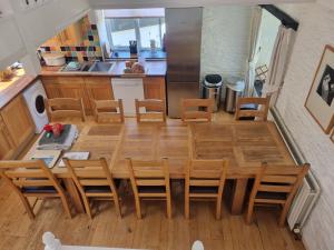 a kitchen and dining room with a wooden table and chairs at Owl Barn in Saltash +3 photos