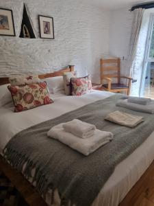 a bedroom with a bed with two towels on it at Owl Barn in Saltash