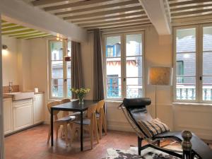 a dining room with a table and chairs and windows at Appartement Le Notre Dame in Honfleur +11 photos