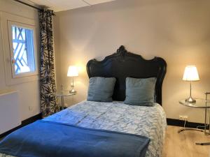 a bedroom with a bed with a blue comforter and two lamps at Appartement Le Notre Dame in Honfleur