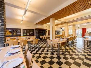 a restaurant with tables and chairs on a checkered floor at Gîte Kaleo Han-Sur-Lesse in Han-sur-Lesse
