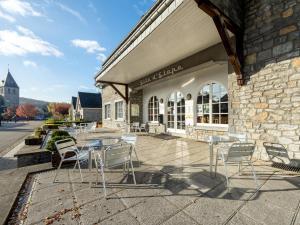 a patio with chairs and a table in front of a building at Gîte Kaleo Han-Sur-Lesse in Han-sur-Lesse