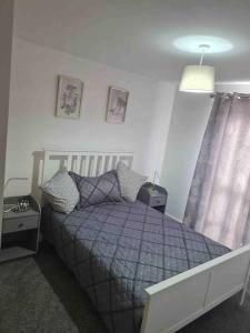 a bedroom with a bed with a purple comforter at Gorgeous Marina 2 Bed Apartment in Portishead +4 photos