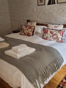 a bed with a blanket and pillows on it at Little Owl in Saltash