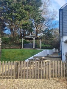 a wooden fence with a picnic table in a yard at Little Owl in Saltash