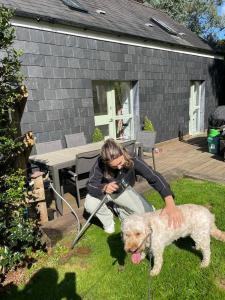 a woman squatting down next to a white dog at Little Owl in Saltash