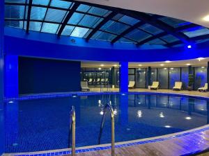 a large swimming pool with blue lighting in a building at Sky Tower Hotel in Batumi