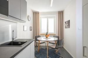 a kitchen with a small table and a window at Kolonie Apartments in Žabovřesky
