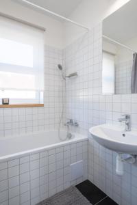 a white bathroom with a sink and a shower at Kolonie Apartments in Žabovřesky +33 photos