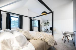 a bedroom with a white bed and a table at No 4 The Halesworth in Halesworth