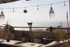 a patio with potted plants and a view of the ocean at Monza Surf House in Tamraght Ouzdar +14 photos