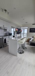 a large white kitchen with a counter and chairs at Corner unit 3 bath and 2 bed in Vaughan