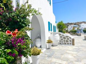 a row of white pots with flowers on a building at Cyclades Blue in Ornos