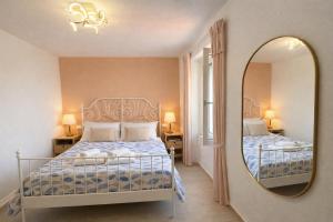 a bedroom with a bed and a mirror at Casa Tiffany - Elba Affitti in Rio nellʼElba
