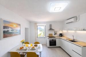 a kitchen with a table and chairs in a room at Casa Tiffany - Elba Affitti in Rio nellʼElba