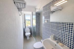 a bathroom with a sink and a toilet and a mirror at Casa Tiffany - Elba Affitti in Rio nellʼElba