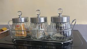 three tea pots sitting on top of a counter at Gated executive 1 bed in gated near Top Malls, Kisumu in Kisumu +19 photos