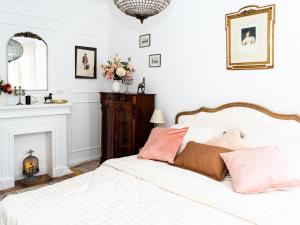 a bedroom with a bed with white sheets and pink pillows at Altstadt Geverdes 1 in Lübeck
