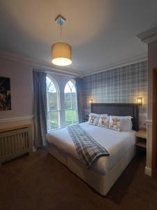 a bedroom with a bed and a large window at Fox and Pheasant Inn in Armathwaite