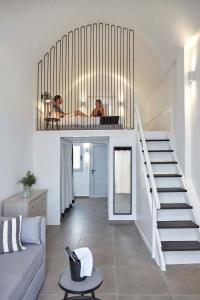 a living room with a staircase in a house at Mr and Mrs White Oia - Santorini in Oia