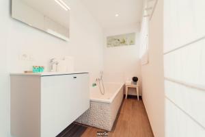 a bathroom with a sink and a bath tub at Villa Promenade - luxuriously apartment for 8 people in Nieuwpoort +31 photos