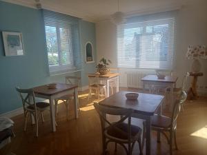 a dining room with two tables and chairs and windows at Un B&B à Loktudi in Loctudy +11 photos