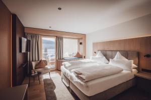 a bedroom with a large bed and a window at Wellnesshotel Sonnenhalde Tonbach in Baiersbronn +45 photos