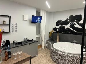 a bathroom with a tub and a sink and a tv at Romantic Room Šiauliai in Šiauliai +24 photos