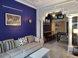 a living room with a couch and a blue wall at Bed N Banter - Lucknow in Lucknow