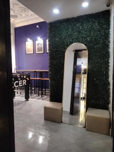 a green wall with a mirror in a lobby at Bed N Banter - Lucknow in Lucknow