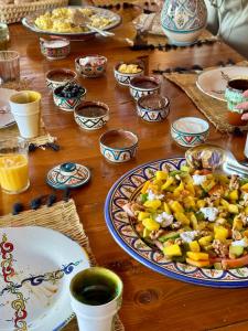 a wooden table with a plate of food on it at Monza Surf House in Tamraght Ouzdar
