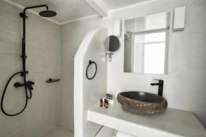 a bathroom with a sink and a mirror at Mr and Mrs White Oia - Santorini in Oia