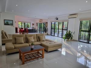 a living room with a couch and a table at Bohol White House Bed & Breakfast in Lila