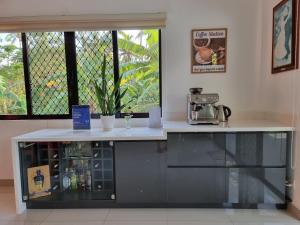 a counter in a kitchen with a coffee station at Bohol White House Bed & Breakfast in Lila