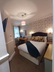 a hotel room with a bed and a desk at Fox and Pheasant Inn in Armathwaite