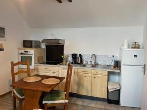 a kitchen with a table and a white refrigerator at La Requeyrie in Montignac