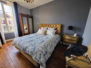 ein Schlafzimmer mit einem Bett, einem Stuhl und einem Fenster in der Unterkunft L'Armancine, chambres d'hôtes in Saint-Florentin